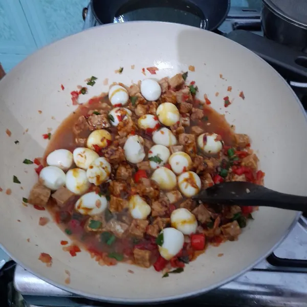 Masukkan air, saus tiram, kecap, laos, dan daun jeruk. Kemudian tempe dan telur puyuh. Aduk-aduk tunggu hingga tercampur rata dan air menyusut.