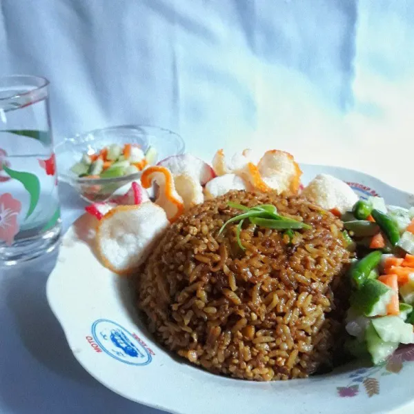 Nasi goreng kemiri kecap siap diasajikan bersama pelengkap sesuai selera.