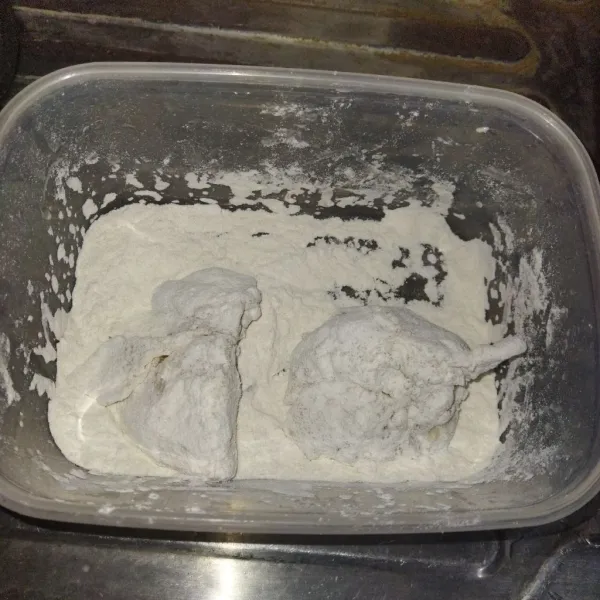 Potong ayam menjadi tiga bagian, kemudian cuci bersih, kemudian balurkan ke dalam tepung, kemudian celupkan ke dalam air es selama satu menit, kemudian gulingkan kembali ke dalam tepung.