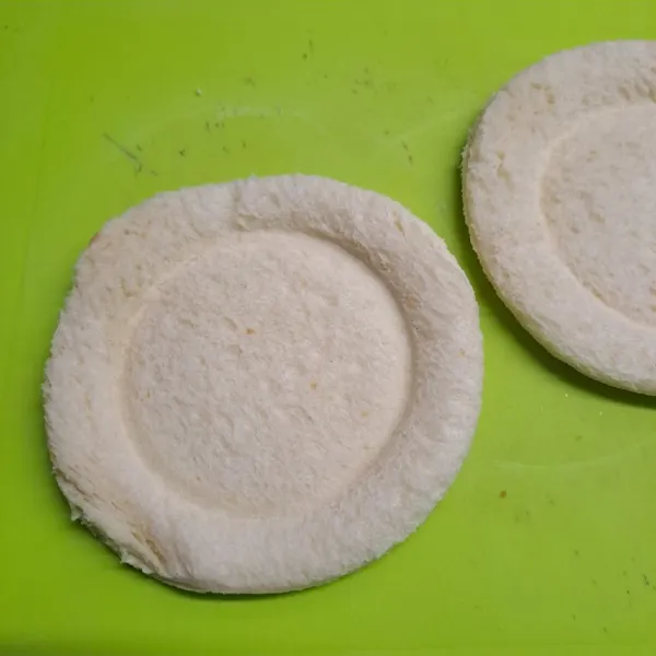 Tekan tengah roti dengan bagian bawah gelas agar membentuk cekungan.