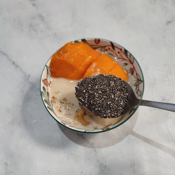 Tata mangga diatas granola, lalu taburi dengan chia seeds