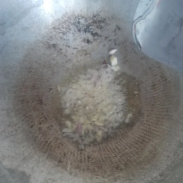 Panaskan minyak lalu tumis bawang putih dan bawang merah yang sudah dicincang sampai menguning dan harum.