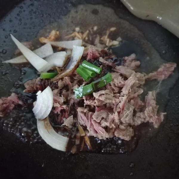 Masukkan daging yang sudah disuwir, daun bawang lalu tambahkan air dan kecap manis. Bumbui garam, lada dan kaldu bubuk.