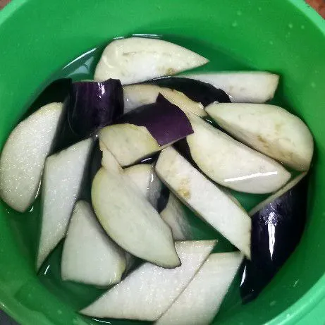 Potong serong terong ungu, lalu rendam dalam air sebentar.