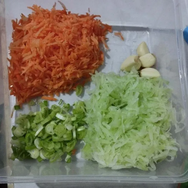 Parut wortel, sebagian buat topping. Labu siam parut, remas-remas dengan garam lalu peras dan buang airnya. Cuci bersih, peras lagi. Sisihkan.