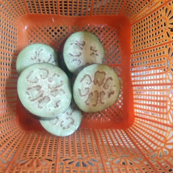 Potong-potong terong, rendam dengan air garam lalu bilas dengan air bersih. Tiriskan.