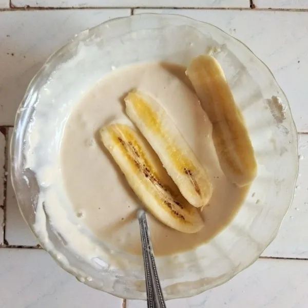 Tambahkan pisang, aduk hingga rata tertutup adonan tepung.