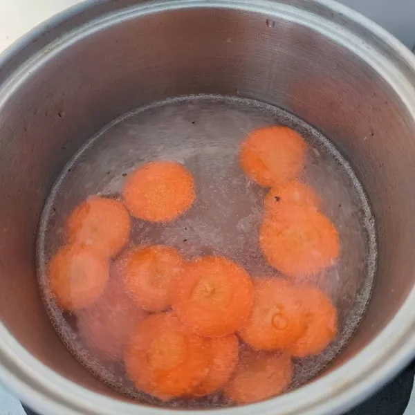 Tambahkan 500 ml air dan potongan wortel. Rebus hingga empuk.