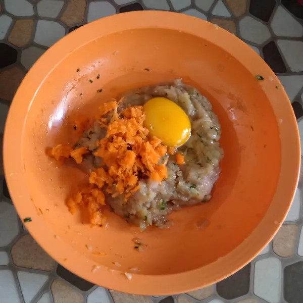 Masukkan 1 butir telur dan wortel yang sudah diparut, aduk hingga rata
