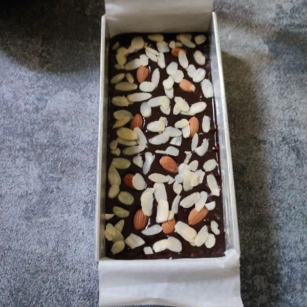 Salin adonan ke dalam loyang yang sudah di alas dengan baking paper. Lalu beri topping almond.