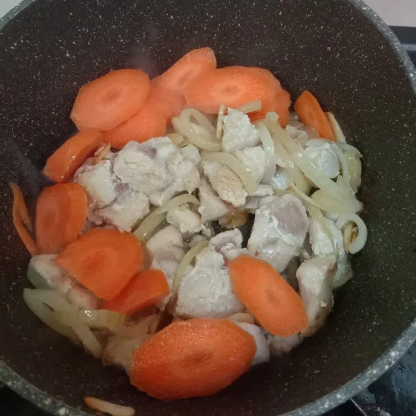 Masukkan ayam, tumis hinggal berubah warna kemudian masukkan wortel. Tambahkan sedikit air lalu tumis hinggal wortel setengah matang.