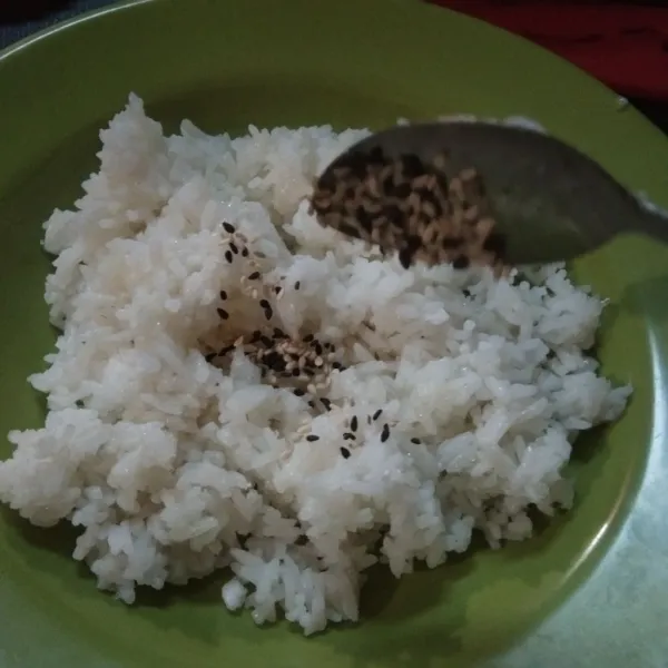 Taruh nasi dipiring. Beri garam, minyak wijen, air lemon, wijen sangrai. Aduk rata sambil nasi ditekan agar bumbu menyerap