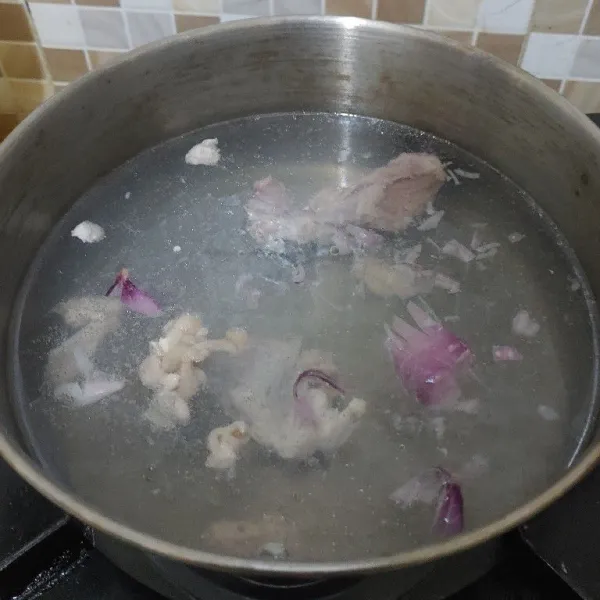 Membuat kuah : didihkan air,masukan tulang ayam,kulit ayam dan bawang merah cincang. Masak sampai mendidih dan kuah berkaldu.