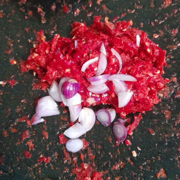 Giling cabe merah dan garam ,lalu tambahkan bawang merah iris