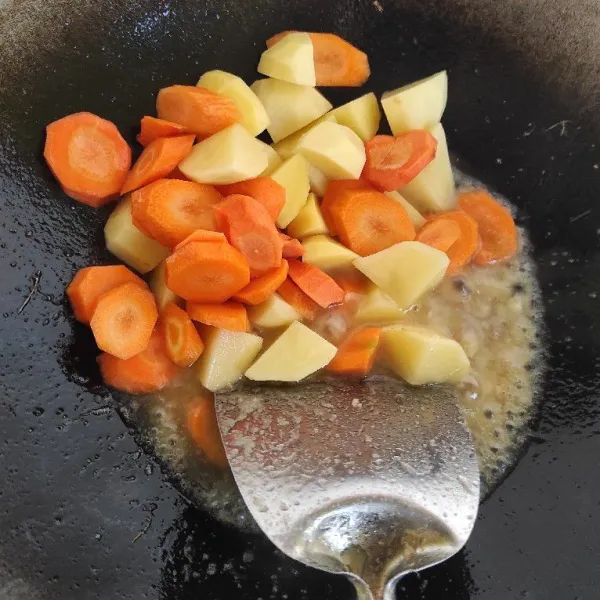 Tumis bawang merah, lalu masukkan bumbu halus. Setelah wangi masukkan wortel dan kentang. Masak hingga empuk