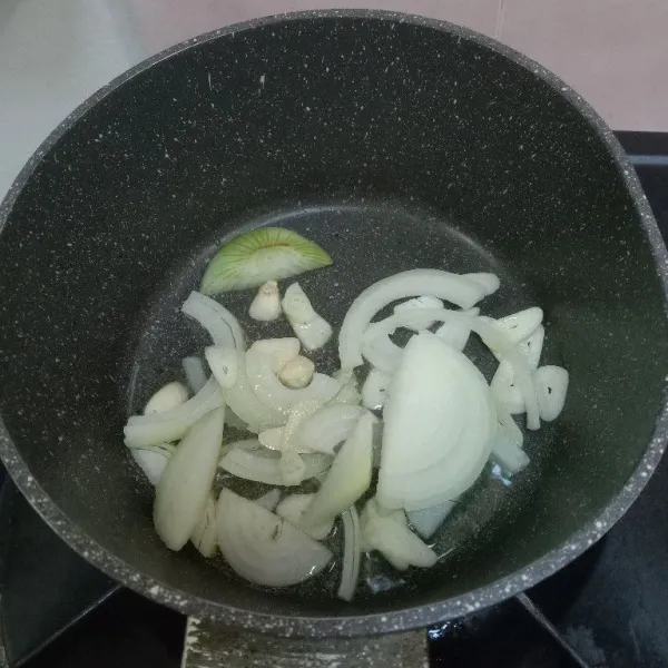 Tumis bawang putih dan bawang bombay yang telah dipotong hingga wangi.