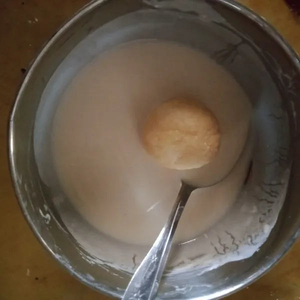 Campur tepung, air aduk rata hingga tidak ada tepung yang menggerindil masuk kan bola bola tape hingga terlumuri tepung permukaan nya