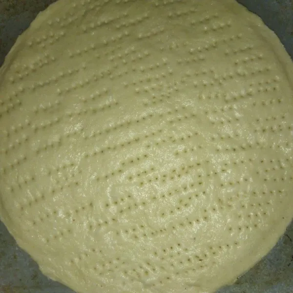 Kempiskan adonan, gilas dan bentuk bulat, pindahkan ke loyang/cetakan pizza, tusuk dough dengan garpu.