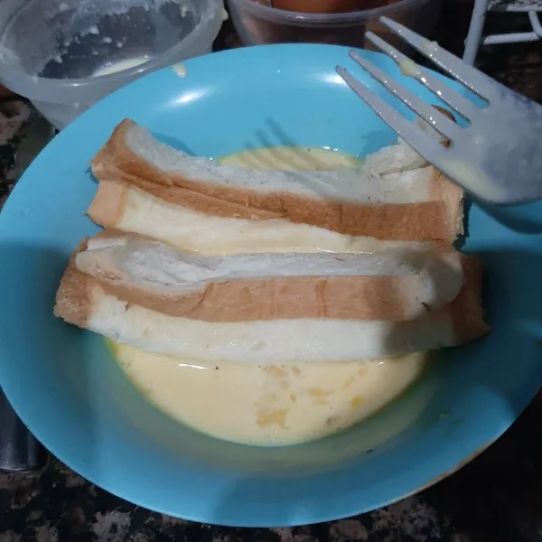 Celupkan roti yang sudah digulung dalam kocokan telur.