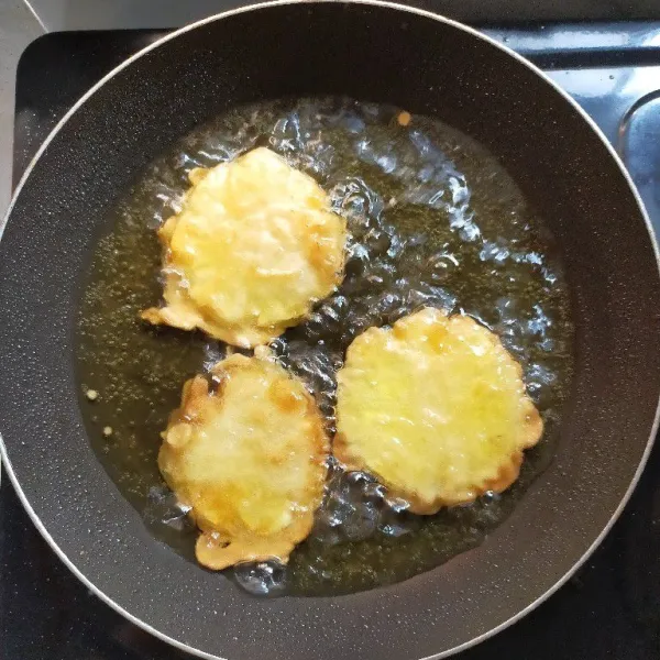 Panaskan minyak, lalu goreng nanas yang telah di balur adonan tepung sampai matang, kemudian angkat dan tiriskan.