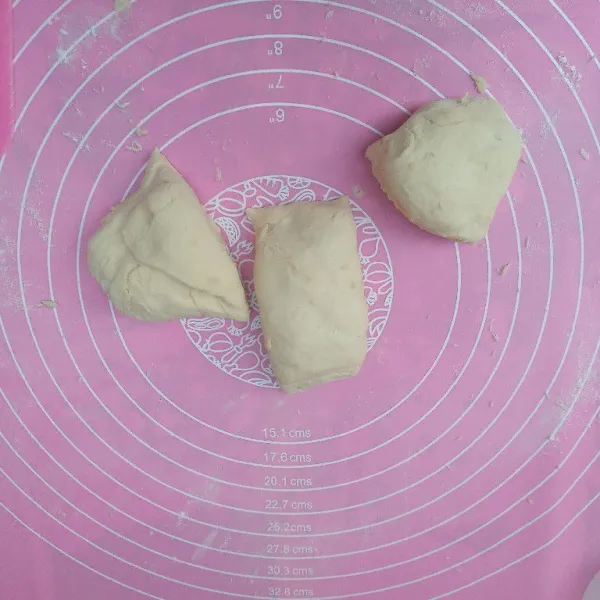 Setelah 1 jam, pindahkan adonan roti ke alas kerja, uleni sebentar lalu bagi menjadi 3 bagian