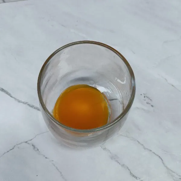 Masukkan sirup jeruk ke dalam gelas.