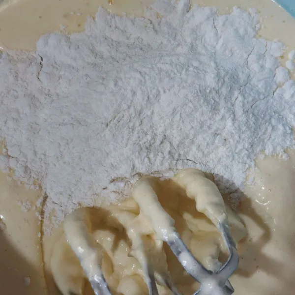 Tambahkan tepung dan baking powder yang sudah diayak, kocok hingga tercampur rata