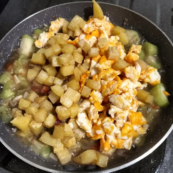 Setelah tomat layu, masukkan kentang dan telur. Aduk