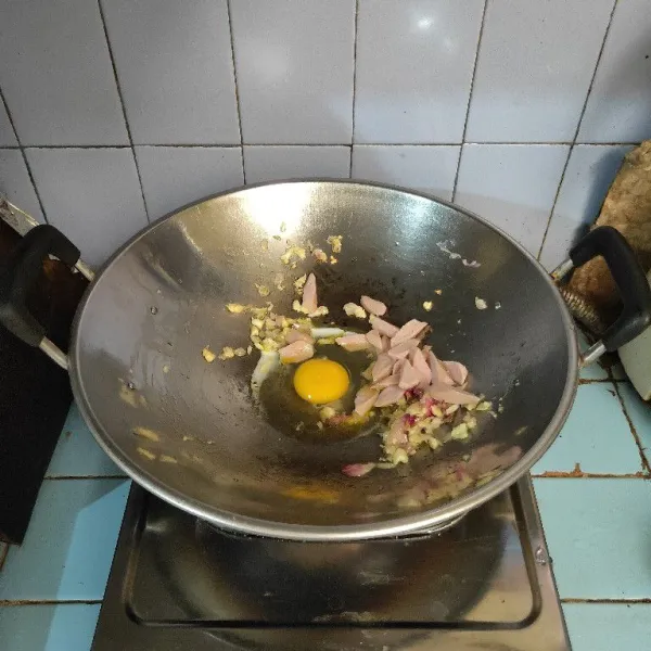 Tambahkan telur dan irisan sosis. Aduk orak arik.