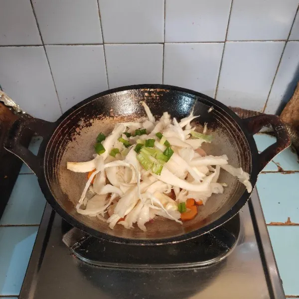Masukkan jamur merang dan daun bawang. Aduk rata.