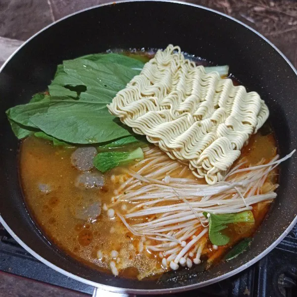 Setelah mendidih masukkan mie, jamur enoki, sawi dan bakso