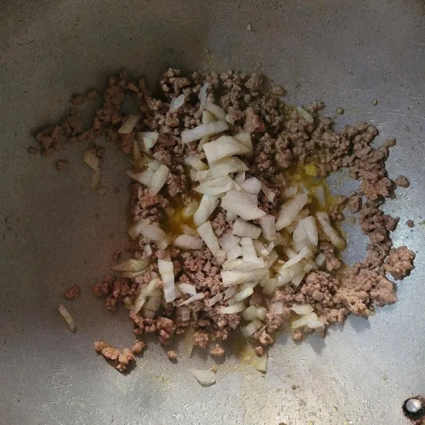 Tumis daging giling menggunakan mentega hingga matang, kemudian masukkan bawang bombay dan aduk hingga bawang bombay layu
