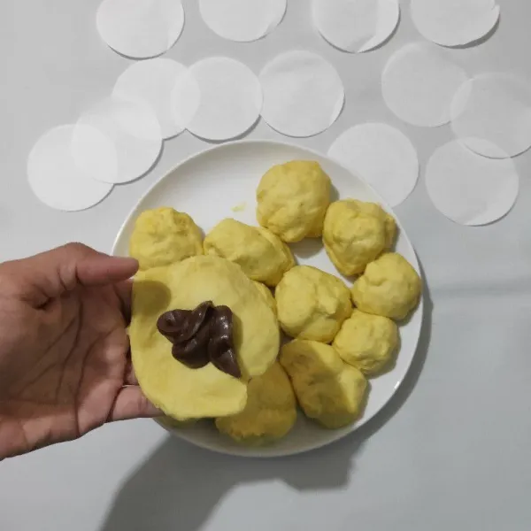 Ambil satu adonan, lalu pipihkan. Kemudian beri isian selai coklat. Bulatkan kembali. Lakukan hingga semua adonan selesai.
