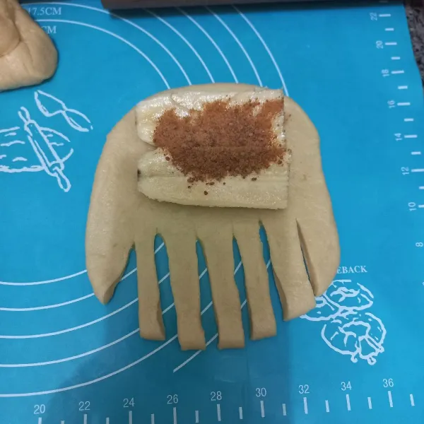 Pipihkan adonan, kerat-kerat dibagian bawah, letakan potongan pisang beri gula aren kemudian lipat dan gulung hingga rapi