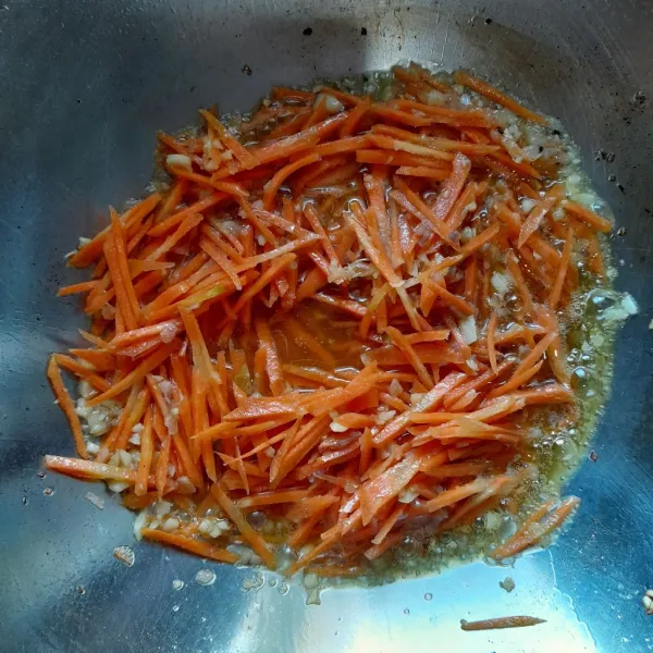 Masukkan irisan wortel,aduk rata,tutup wajan dan masak wortel hingga setengah empuk.