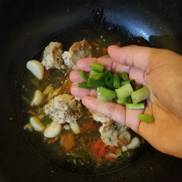 Masukkan daun bawang, aduk rata, matikan api.