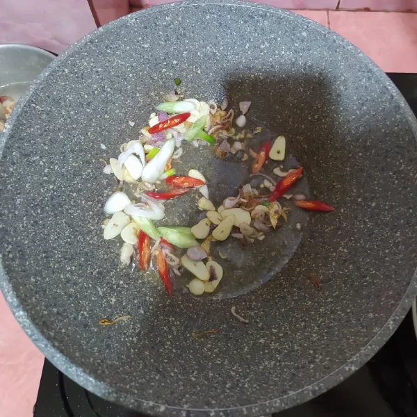 Panaskan minyak lalu tumis bawang merah dan bawang putih sampai wangi. Masukkan cabe dan daun bawang.