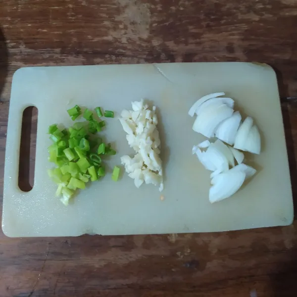 Cincang bawang putih, iris bawang bombay dan daun bawang.