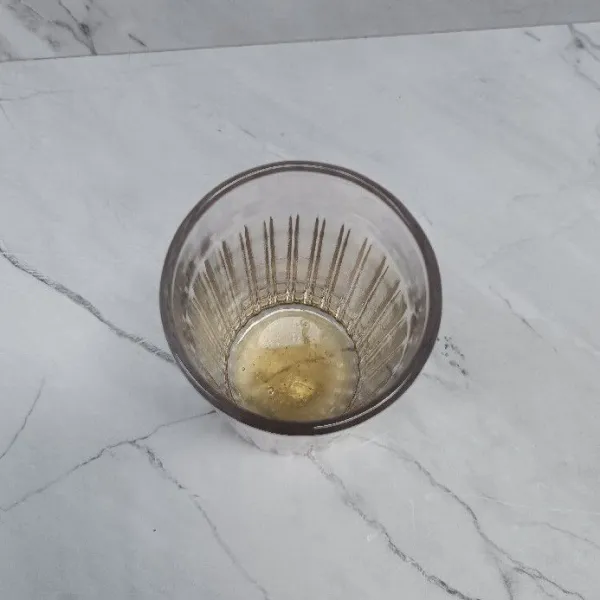 Masukkan madu ke dalam gelas.