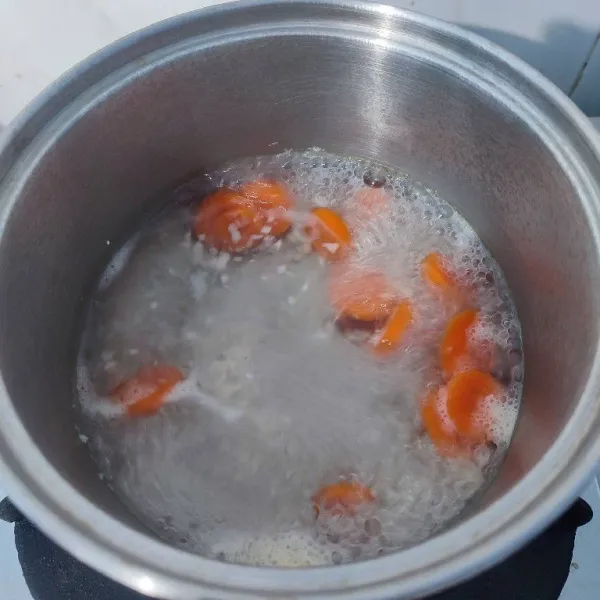 Rebus 500 ml air, bawang putih cincang, wortel dan kaldu jamur.