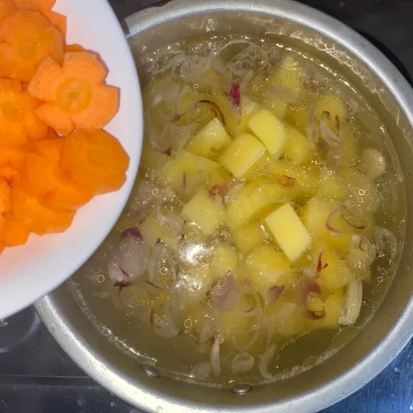 Masukkan kentang dan wortel. Masak sampai kentang setengah matang.