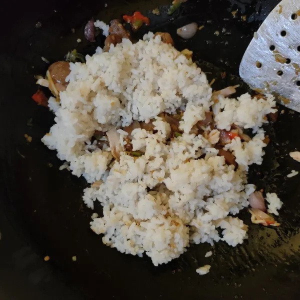 Masukkan nasi dan kaldu bubuk, aduk hingga tercampur rata, tes rasa.