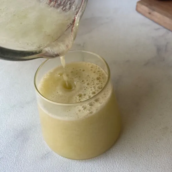 Tuang jus ke dalam gelas yang berisi sari jeruk. Siap disajikan.