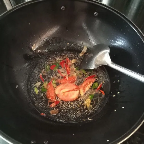 Tumis bawang putih dan bawang merah sampai layu. Masukan air sedikit, dan masukkan juga cabe dan tomat.