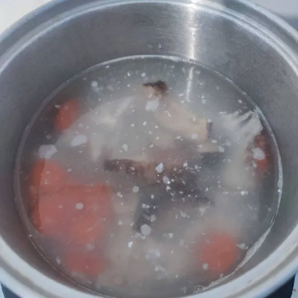 Setelah wortel mulai empuk, masukkan sisa air, air kaldu, potongan dada ayam dan irisan jamur. Rebus sampai mendidih.