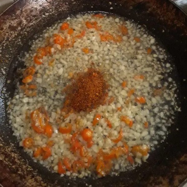 Masukkan cabe rawit merah dan cabe bubuk. Masak hingga bawang dan cabe matang sambil terus di aduk