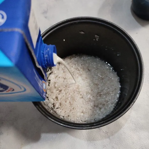Tuang susu cair ke dalam wadah berisi beras.