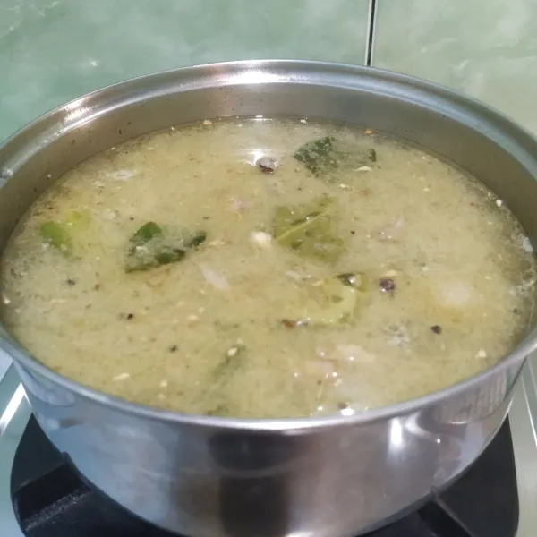 Masukkan bumbu yang telah ditumis ke dalam rebusan tulang.