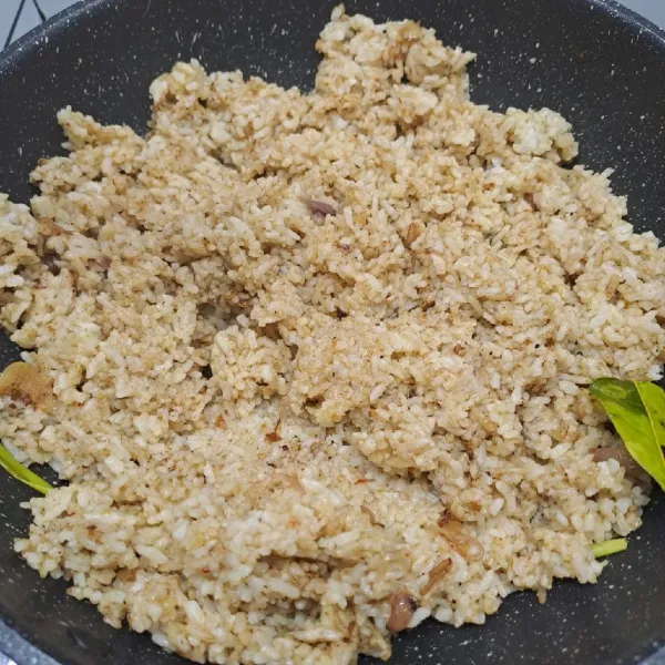 Masukkan nasi, aduk sampai rata. (Bumbu instan rawon sudah asin, jadi tidak perlu ditambahkan garam).
