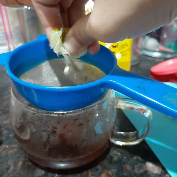 Angkat saringan teh dari gelas, atau jika menggunakan gelas lain saring teh dengan saringan. kemudian tambahkan jeruk nipis saring agar biji jeruk tidak masuk,